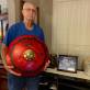 Dad holding the ride cymbal  next to a picture of mom